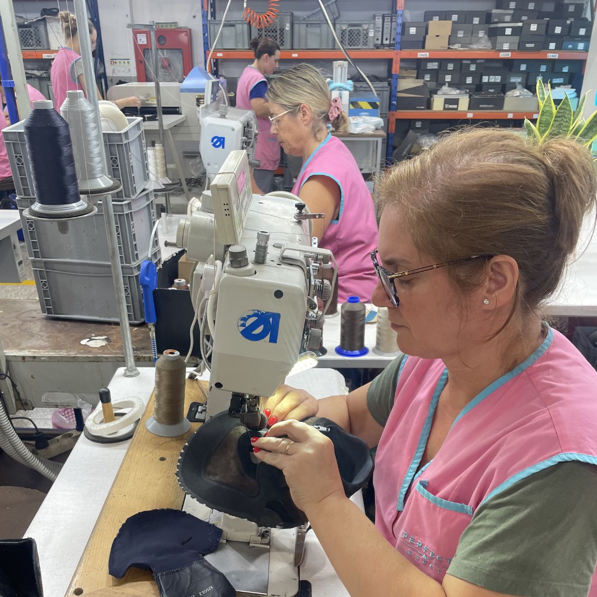 Mitarbeiterin näht ein Schuhoberteil an der Nähmaschine in Portugal