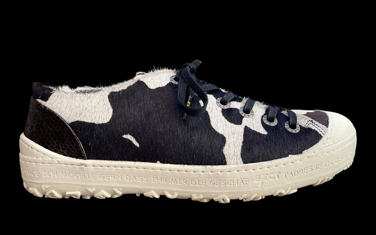 Herren-Sneaker aus Kuhfell in Schwarz-weiss, Seitenansicht des rechten Schuhs