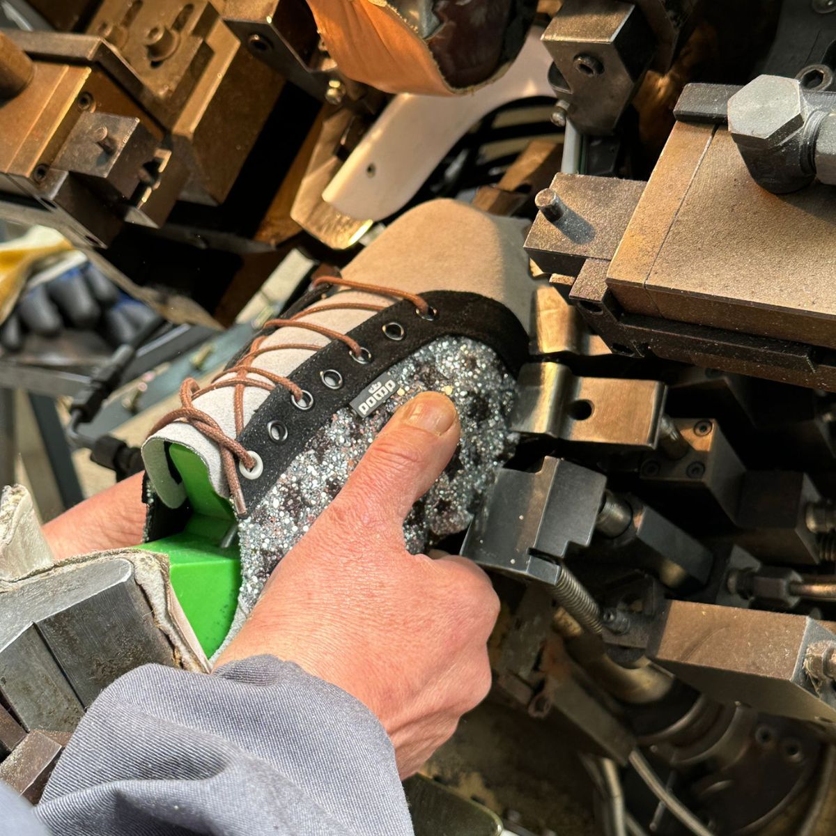 Anpressen der Sohle an der Maschine in der Schuhproduktion in Portugal