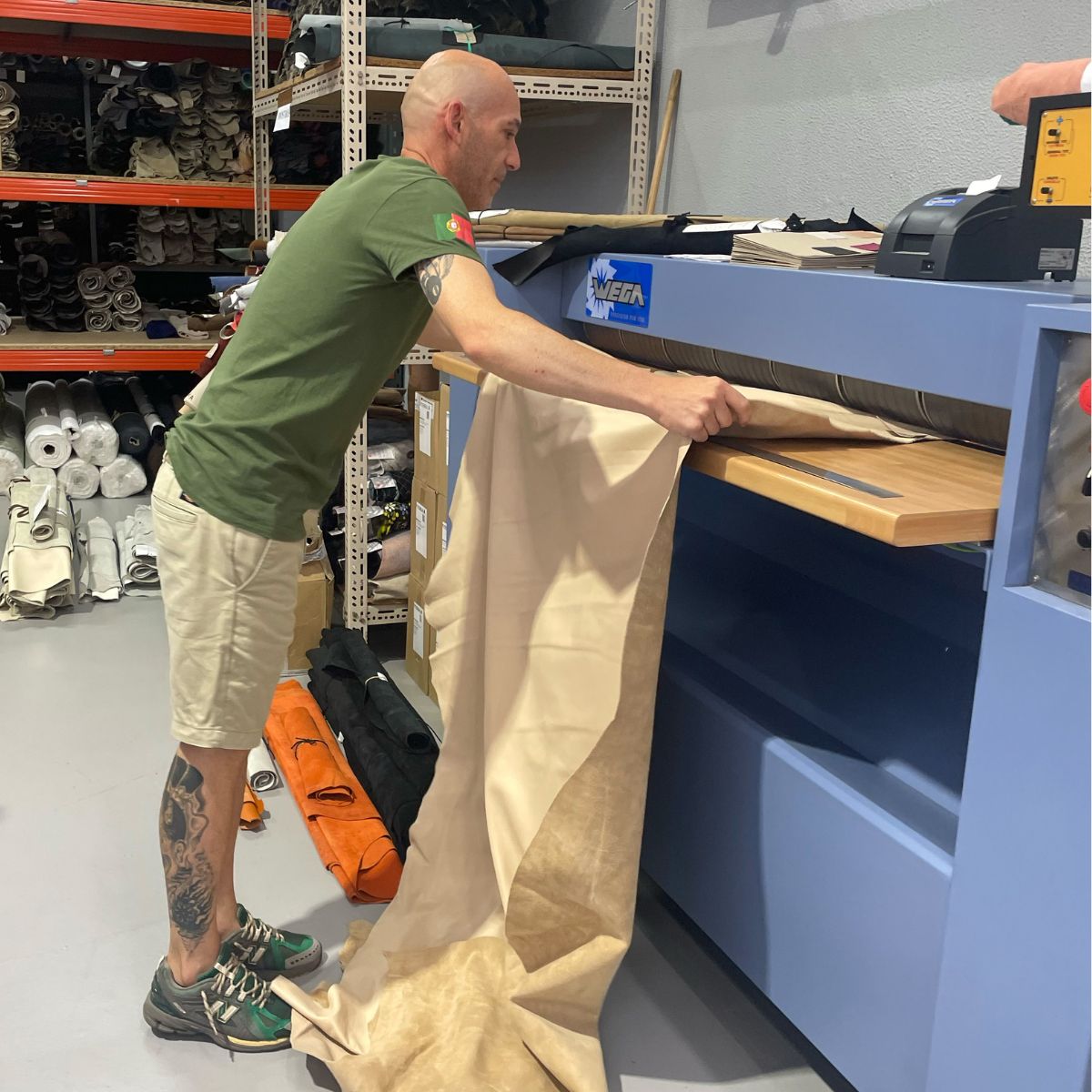 Mitarbeiter prüft Leder im Lager der Schuhproduktion in Portugal